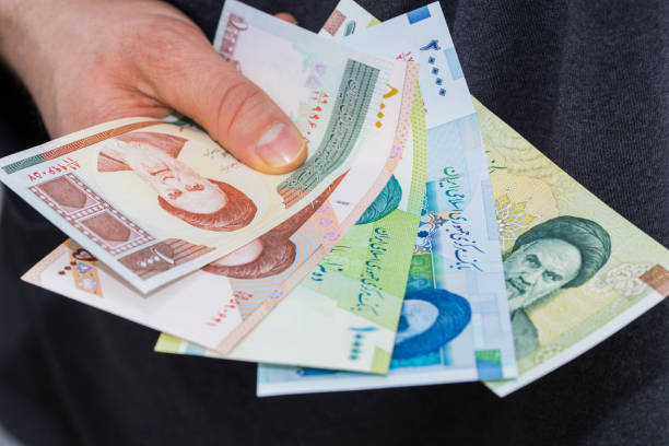 istock Iranian bills, Riyal, Assorted values, Money spread out and held in the hand 1322722872