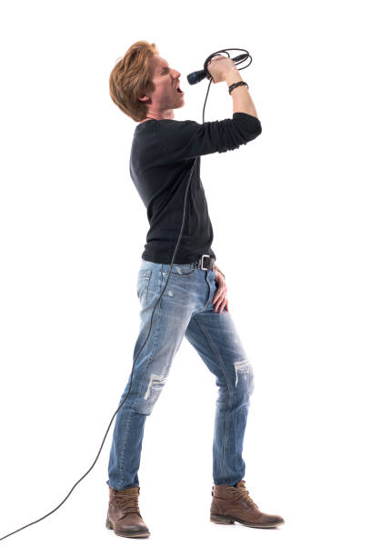 istock Loud energetic young singer singing loud and shouting on microphone. 1322723182