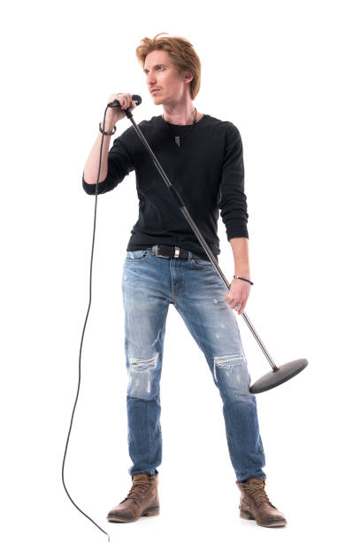 istock Handsome singer in jeans holding microphone posing and looking away. 1322723719