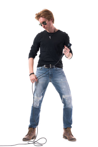 istock Passionate young handsome rock music male singer holding microphone looking down 1322723773