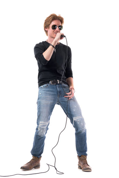 istock Handsome young singer with sunglasses smiling and holding microphone 1322723802