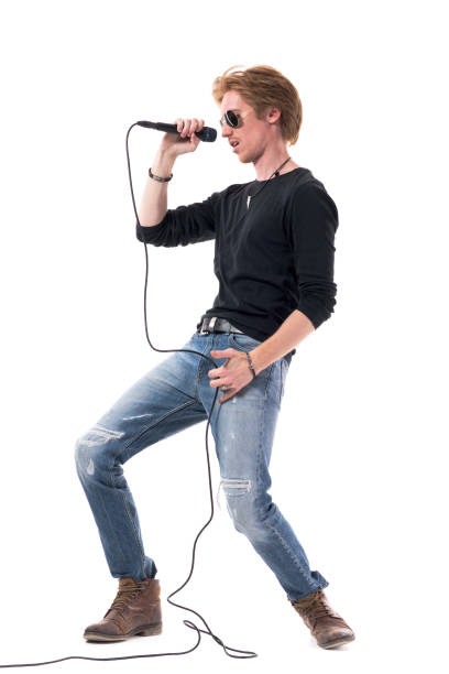 istock Side view of passionate rocker singing on microphone bending backwards. 1322723812