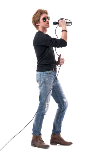 istock Cool rocker male with sunglasses holding microphone. Side view. 1322723834