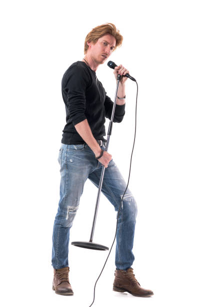 istock Side view of macho rock music singer man singing on microphone on stand 1322723843