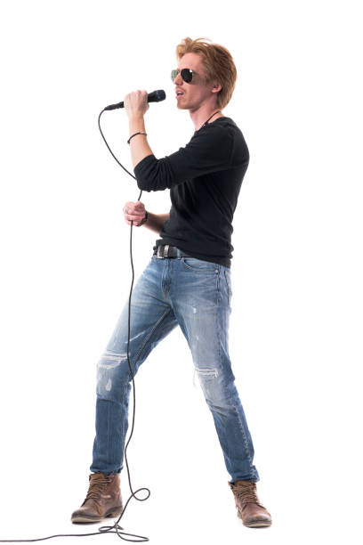 istock Passionate rock music singer singing loud on microphone with energy. 1322723890