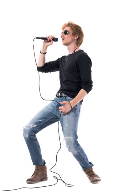 istock Side view of energetic passionate rocker singer singing loud on microphone 1322723920