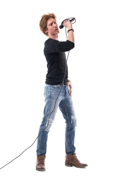 istock Handsome young stylish singer singing on microphone with closed eyes 1322723928