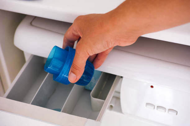 istock Woman hand pouring a liquid detergent in a washing machine. 1322724061