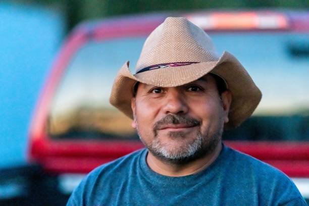 istock Smiling Hispanic farm worker posing wearing a cowboy hat looking at the camera 1322724246