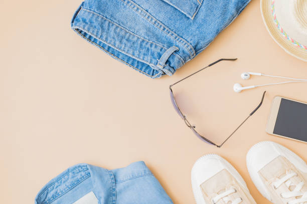 istock Flat lay summer composition with a straw hat, jeans and sneakers on a yellow background 1322727864