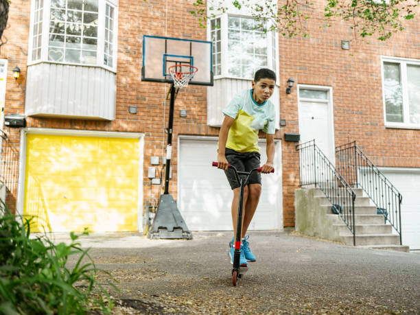 istock Mixed race boy riding scooter in the alley 1322728614