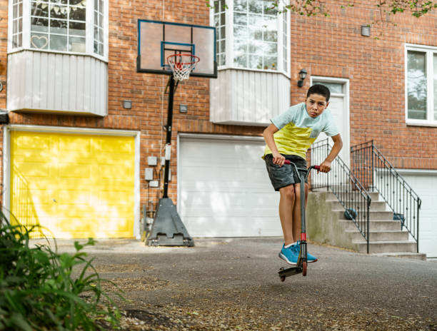 istock Mixed race boy riding scooter in the alley 1322728691