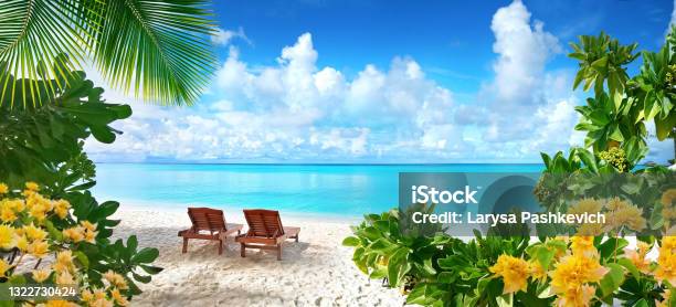 Beautiful Tropical Beach With White Sand And Two Sun Loungers On Background Of Turquoise Ocean And Blue Sky With Clouds Stock Photo - Download Image Now