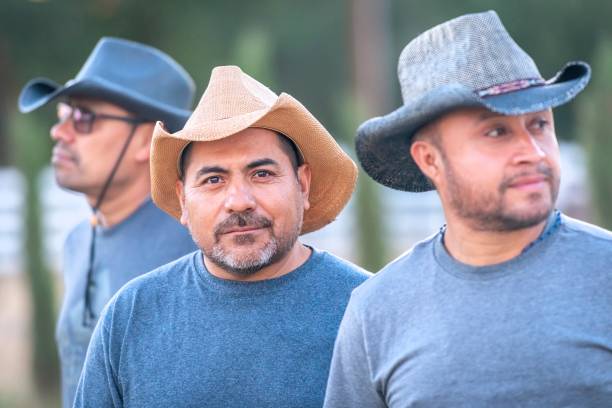 tres trabajadores agrícolas maduros hispanos con sombreros de vaquero mirando a la cámara sonriendo - aliens and cowboys fotografías e imágenes de stock