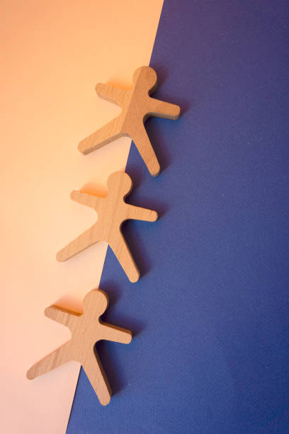 istock Wooden men with Shadow under direct sunlight on blue and pink paper background. 1322734791