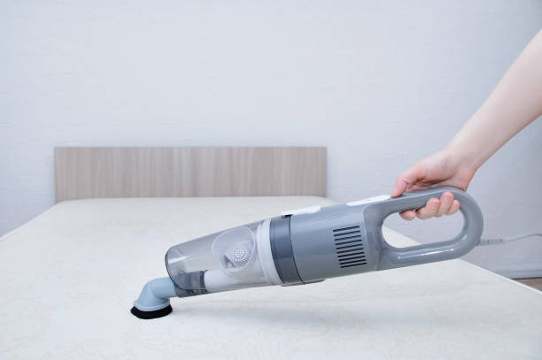 вакуумный матрас кровати. портативный пылесос в руке кавказки. - mattress cleaning vacuum cleaner housework стоковые фото и изображения