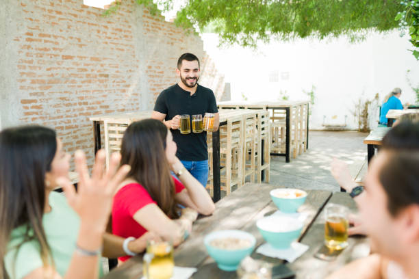 istock Happy latin man serving beer to his friends 1322736608