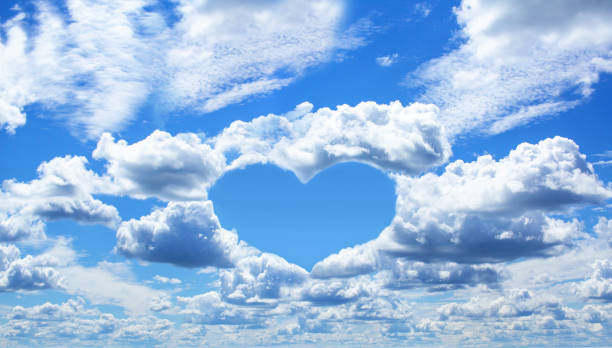 istock Blue sky with white clouds, love theme background. Clear blue sky with heart-shaped clouds with space for text 1322740811