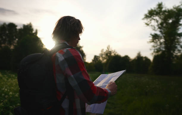 istock Male tourist with map and backpack in the forest. 1322742297
