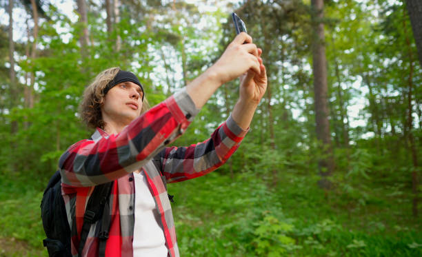 istock Man doing selfie with smartphone in the forest. 1322742311