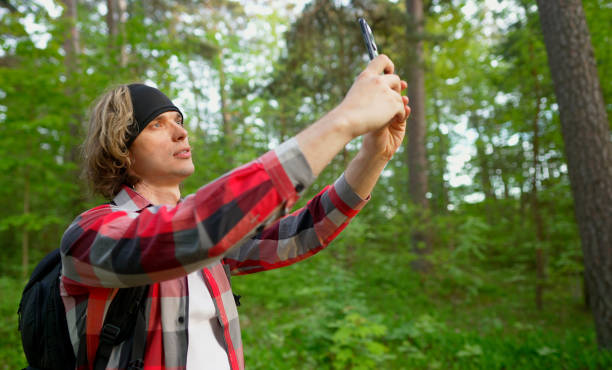 istock Man doing selfie with smartphone in the forest. 1322742314