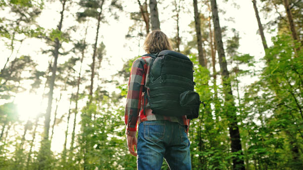 istock Man with backpack and sunglasses in the woods. Arc shoot. 1322742374