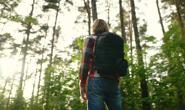 istock Man with backpack and sunglasses in the woods. Arc shoot. 1322742376