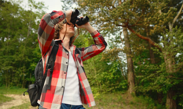 istock Man with rucksack and binoculars in the forest. 1322742382