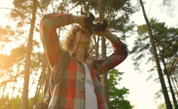 istock Man with rucksack and binoculars in the forest. 1322742388