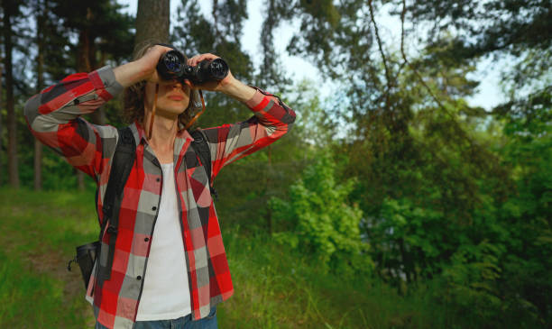 istock Man with rucksack and binoculars in the forest. 1322742410
