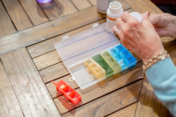 istock A senior woman sorting out her medicament, placing them into the pill organizer 1322743713