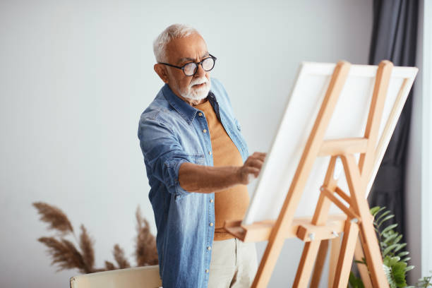 istock Senior artist painting on canvas at home studio. 1322745228