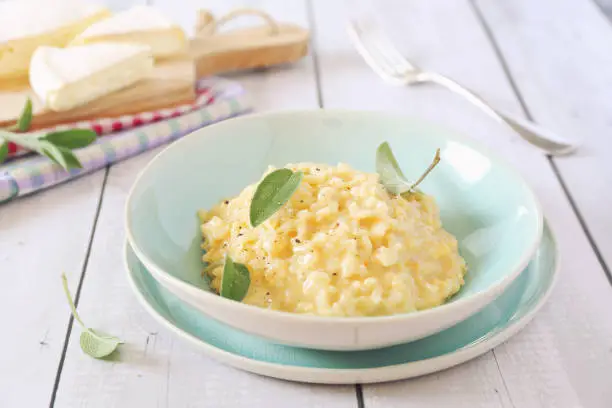 Creamy Brie cheese Risotto on sage broth, light background