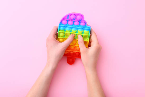 istock Colorful antistress silicone toy fidget push pop it on pink background 1322746277