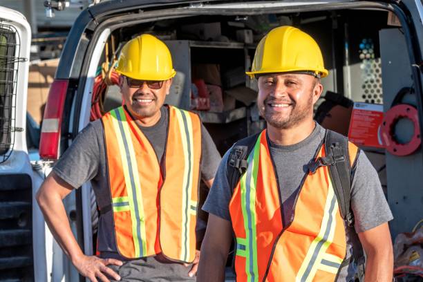 istock Smiling hispanic construction workers wearing a work helmet looking at the camera 1322746611