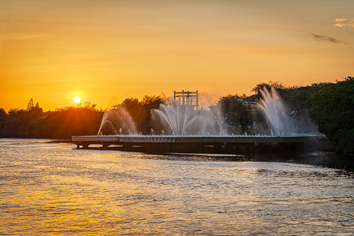 Big fountain at sunset, taken from the Puente del Velero (Sailboat Bridge), with a forest in the background, Guayaquil, Ecuador.
