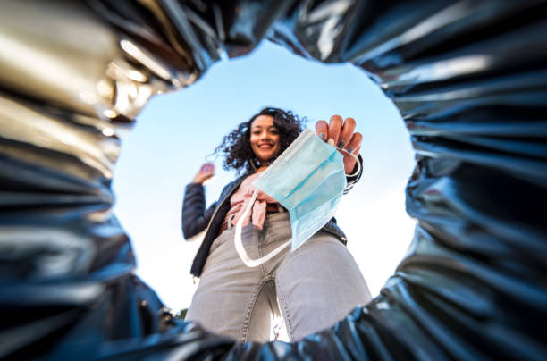 kobieta wyrzucająca używaną ochronną maskę chirurgiczną do kosza na śmieci od wewnątrz - garbage bag garbage bag plastic zdjęcia i obrazy z banku zdjęć