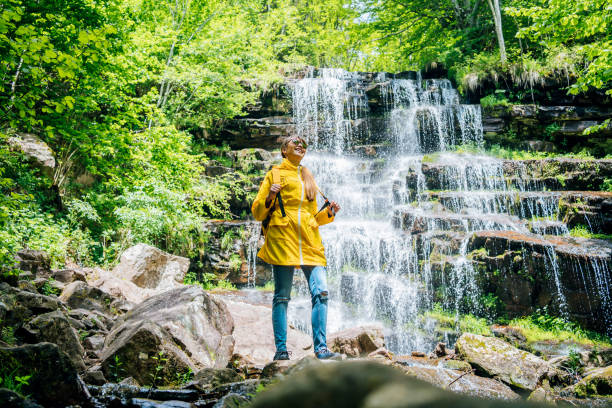 junge frau steht vor wasserfall - waterfall water nature zen like stock-fotos und bilder