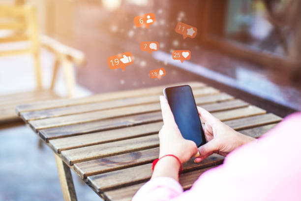 istock Concept with a Girl using a smartphone and communicating on social networks with likes, subscribers and comments 1322753187