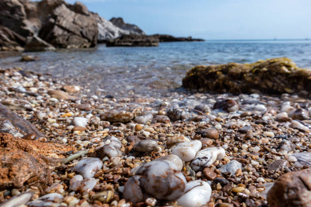 istock Aegean sea pebble beach with cliffs and blue water 1322755681