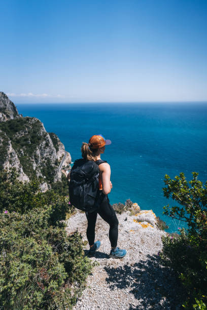 istock Female hiker relaxes at waterfront viewpoint 1322756788