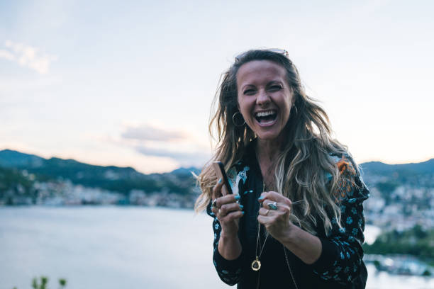 istock Young woman texts on cellphone from lakefront viewpoint 1322756972