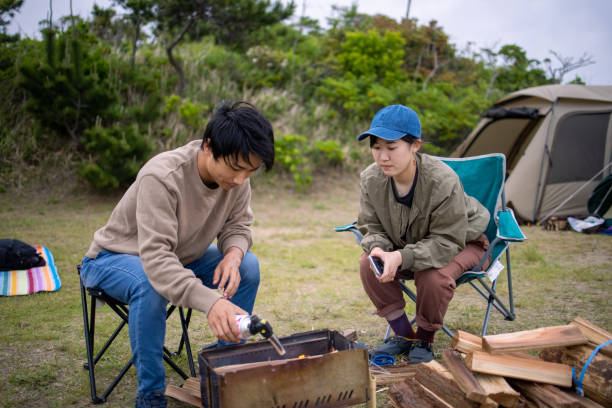 istock Young man lighting firewood at camp 1322760388