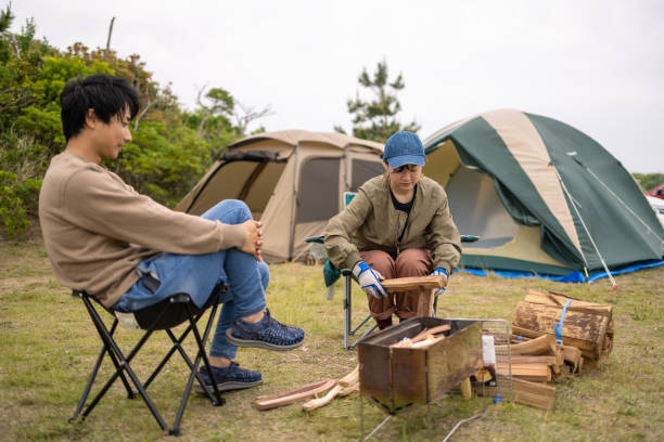 istock Young woman cutting firewood at camp 1322760444