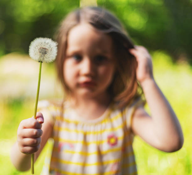 istock Girl Holding Dandelion 1322760451