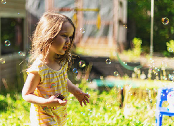istock Girl Playing With Bubbles In Backyard 1322760482