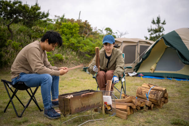 istock Young woman cutting firewood at camp 1322760528