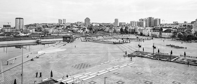 Cheboksary, Russia - October 08, 2020: A wide panorama of the city of Cheboksary. Red Square in the city of Cheboksary. People walking on the square on a cloudy day. Black and white panoramic photo.