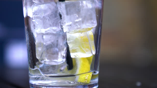 Glass Of Ice Filled Drink. Can Be Water, Any Beverage Or Any Alcholic Drink. It Is Being Drunk With A Straw And As Long As It Is Being Drunk, Level Of Liquid Is Decreasing Through Bottom Of The Glass.