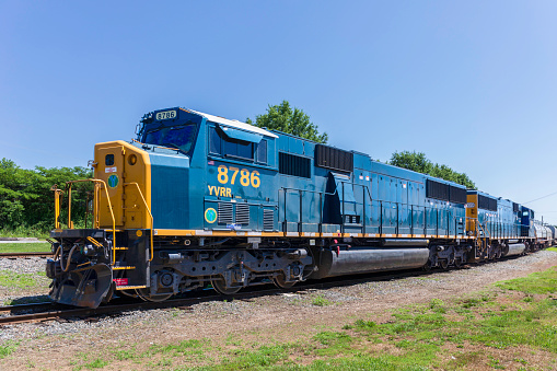 Elkin, NC, USA-5 June 2021: A blue and yellow locomotive and and train cars marked as \